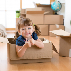 Flicka i flyttkartong